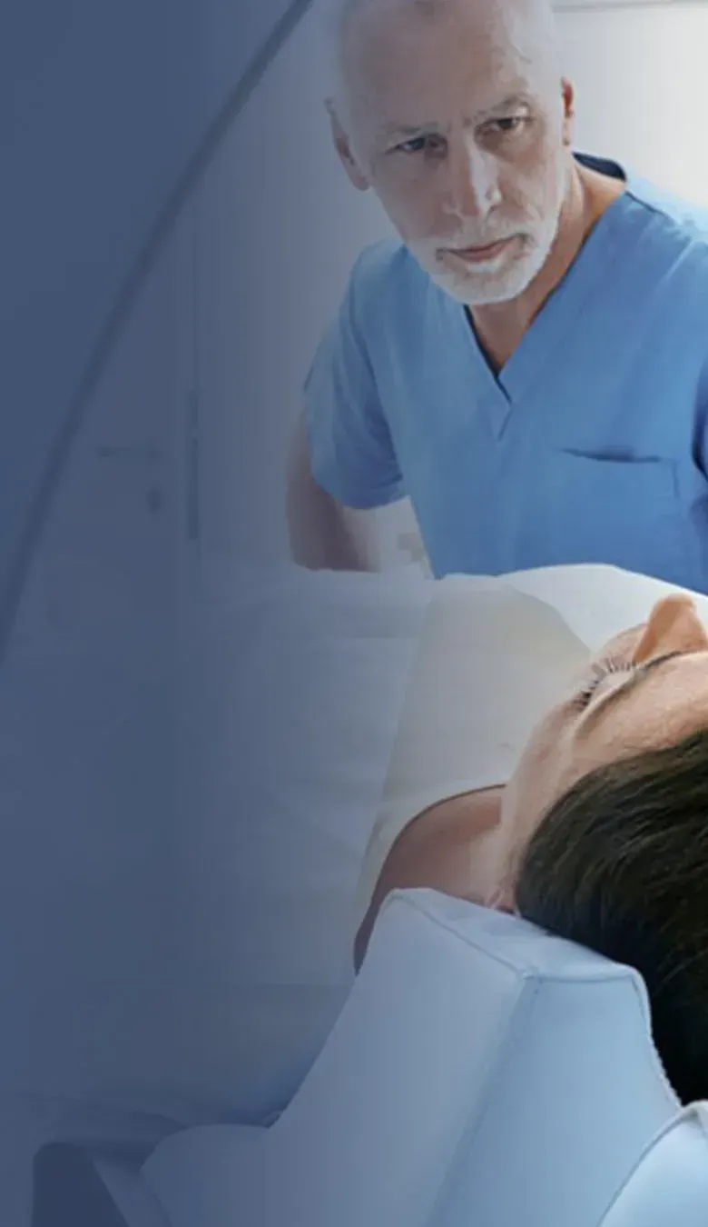 Patientin liegt in der Praxis für Radiologie und Nuklearmedizin in der Kaiser-Passage in einem CT-Gerät, während ein Radiologe die Untersuchung vorbereitet.